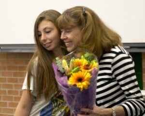 Sandy Spiewak receives flowers from a TPC Teen at end of year event